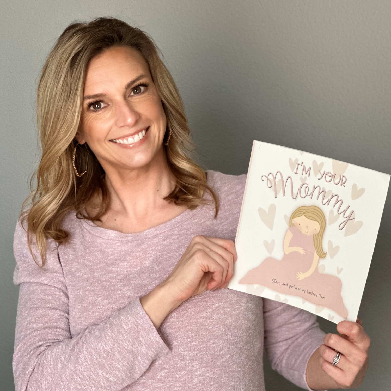 Self Published Author and Illustrator Lindsay Dain holding her children's picture book titled "I'm Your Mommy" created on the Kindle Direct Publishing platform. 